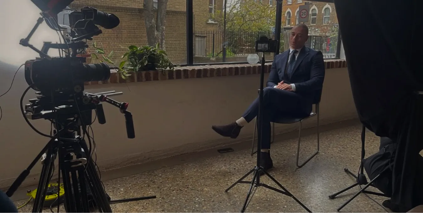 The full interview setting: camera and tripod on the left, Charles Thomas seated on the right